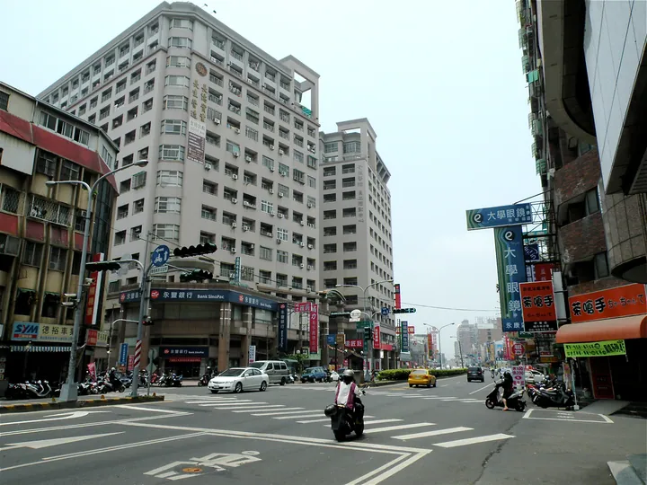 A busy urban street intersection with shops, banks and traffic in Yongkang District, Tainan