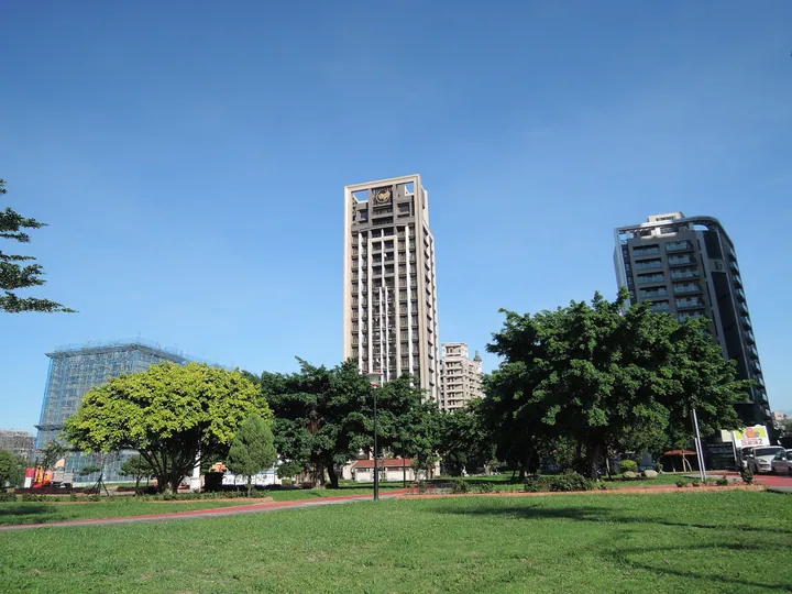 A landscaped park with trees and apartment towers in Bade District, Taoyuan