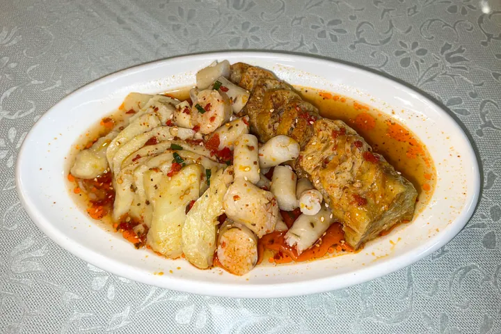 A plate of sliced stuffed sheep lung (öpke) in chili oil.