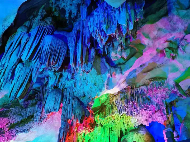 Colourfully lit limestone stalactites inside a cave