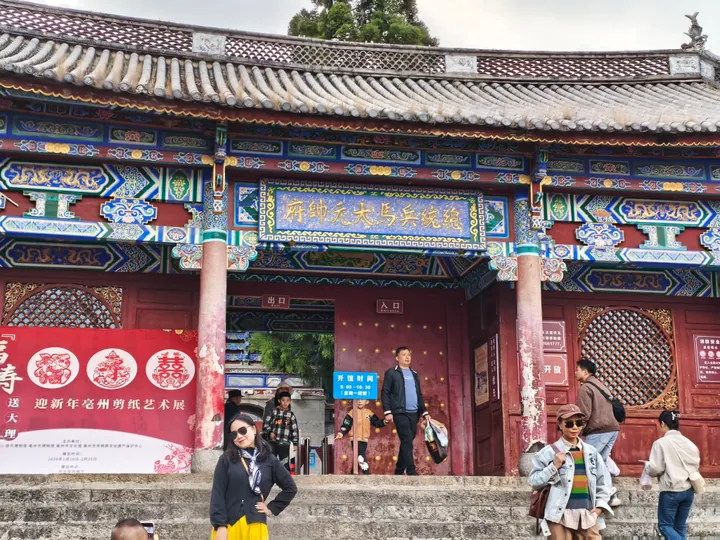 Ornate traditional gate hall with visitors inside Dali Old Town