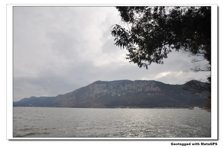 View across Dianchi Lake toward a cliff-lined shoreline