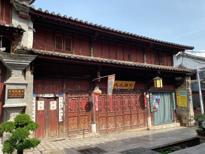 Old two-storey wooden building with a tiled roof on a street in Tonghai Old Town