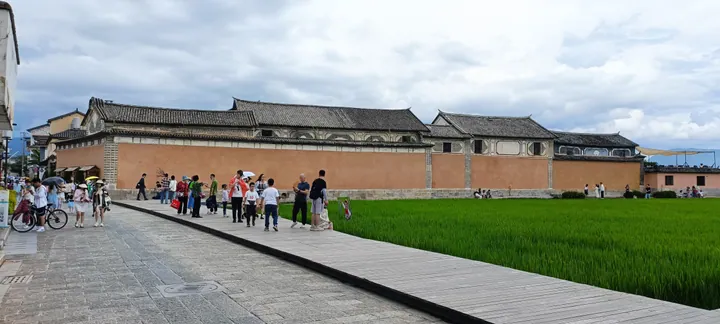 Traditional courtyard wall and green rice fields at Xizhou old town