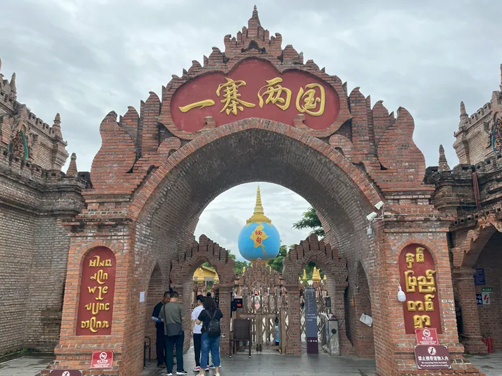 Decorated brick archway marked 一寨两国 at the border tourist site