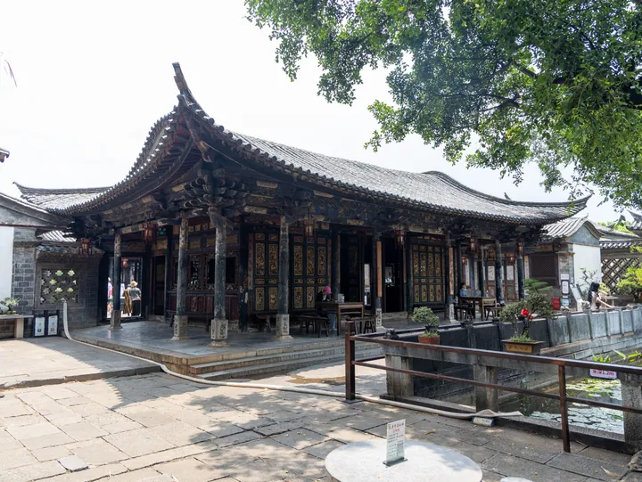 Ornate carved wooden hall with courtyard and pond in Zhu's Garden, Jianshui