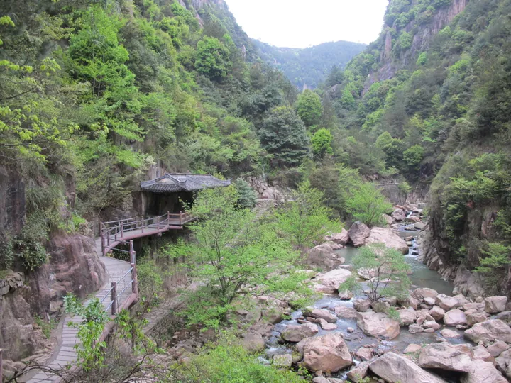 Wooden pavilion and walkway along a forested gorge stream at Qiongtai Xiangu
