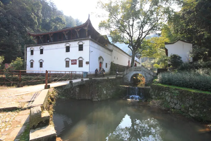 Temple hall and arched stone bridge over a stream in Yuyuan Village
