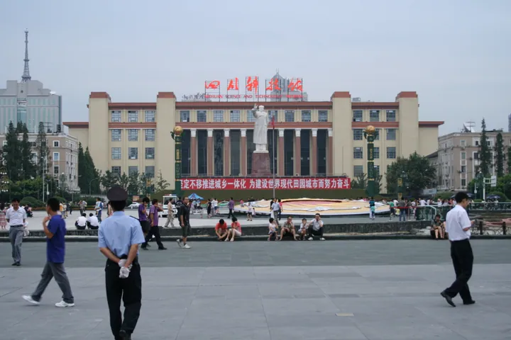 Exterior of the Sichuan Science and Technology Museum behind Tianfu Square in Chengdu, with a statue of Mao Zedong in front