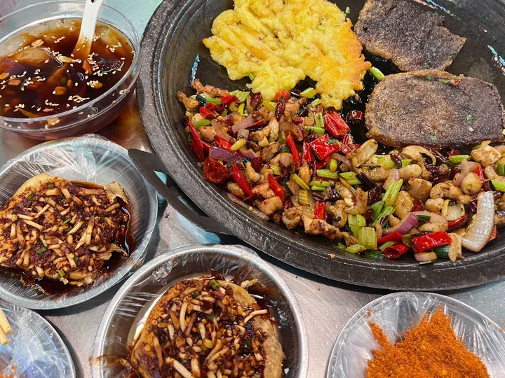 Guizhou lao guo round iron griddle pan with fried food and dipping sauces
