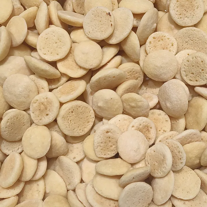 A pile of small round pale wafer-like soybean cakes