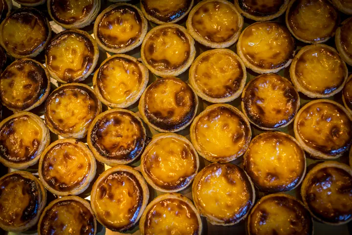 A tray of Portuguese egg tarts with caramelised tops
