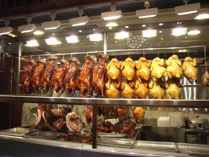 Roast goose and chicken hanging in a Cantonese siu mei / shao la shop display case
