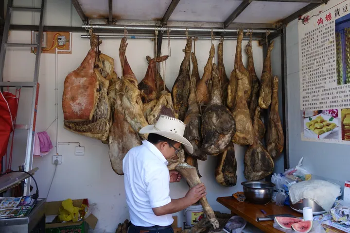 Rows of cured ham legs hanging in a Xuanwei ham shop.