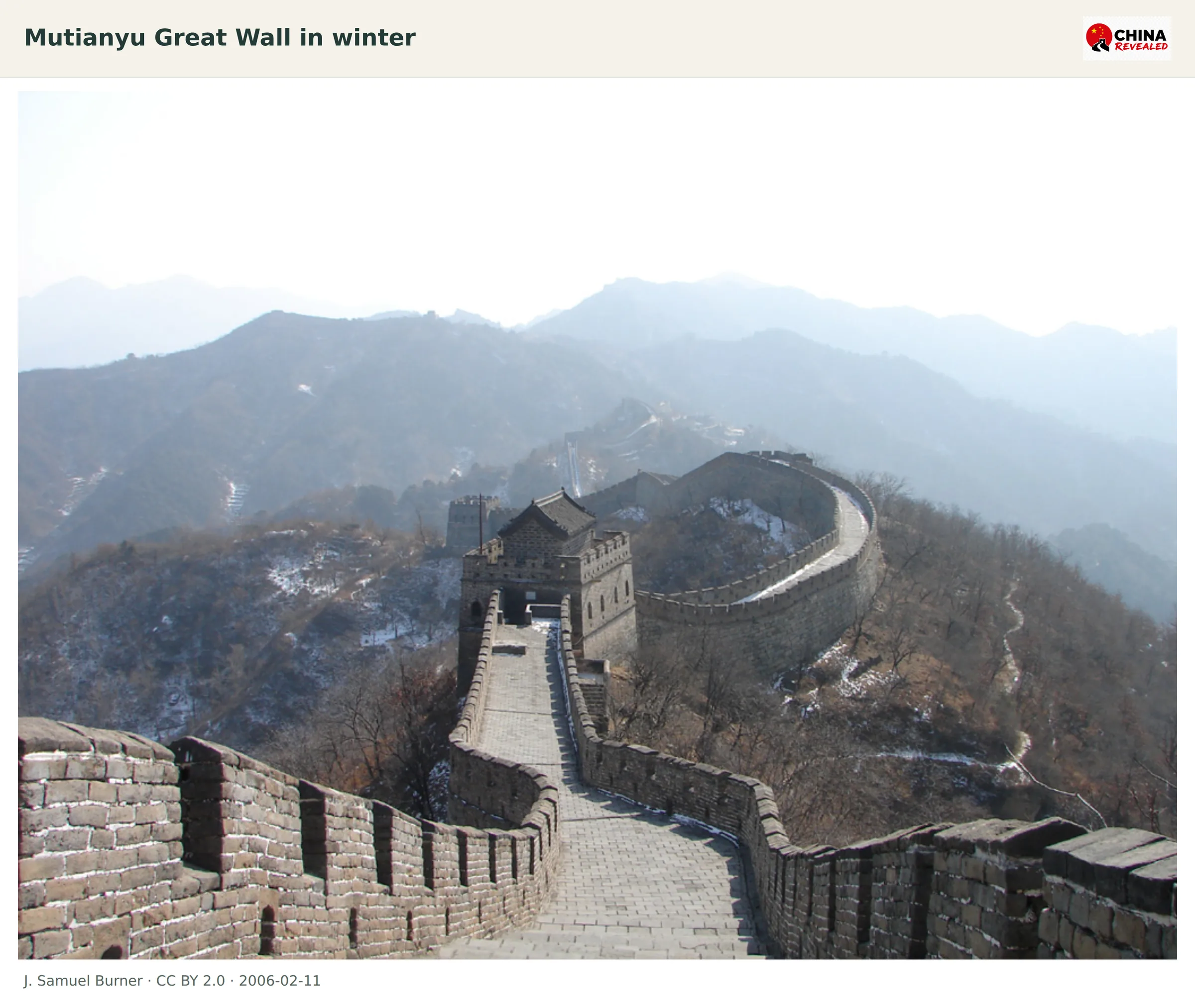 A snow-dusted watchtower and crenellated wall winding along the Mutianyu mountain ridge