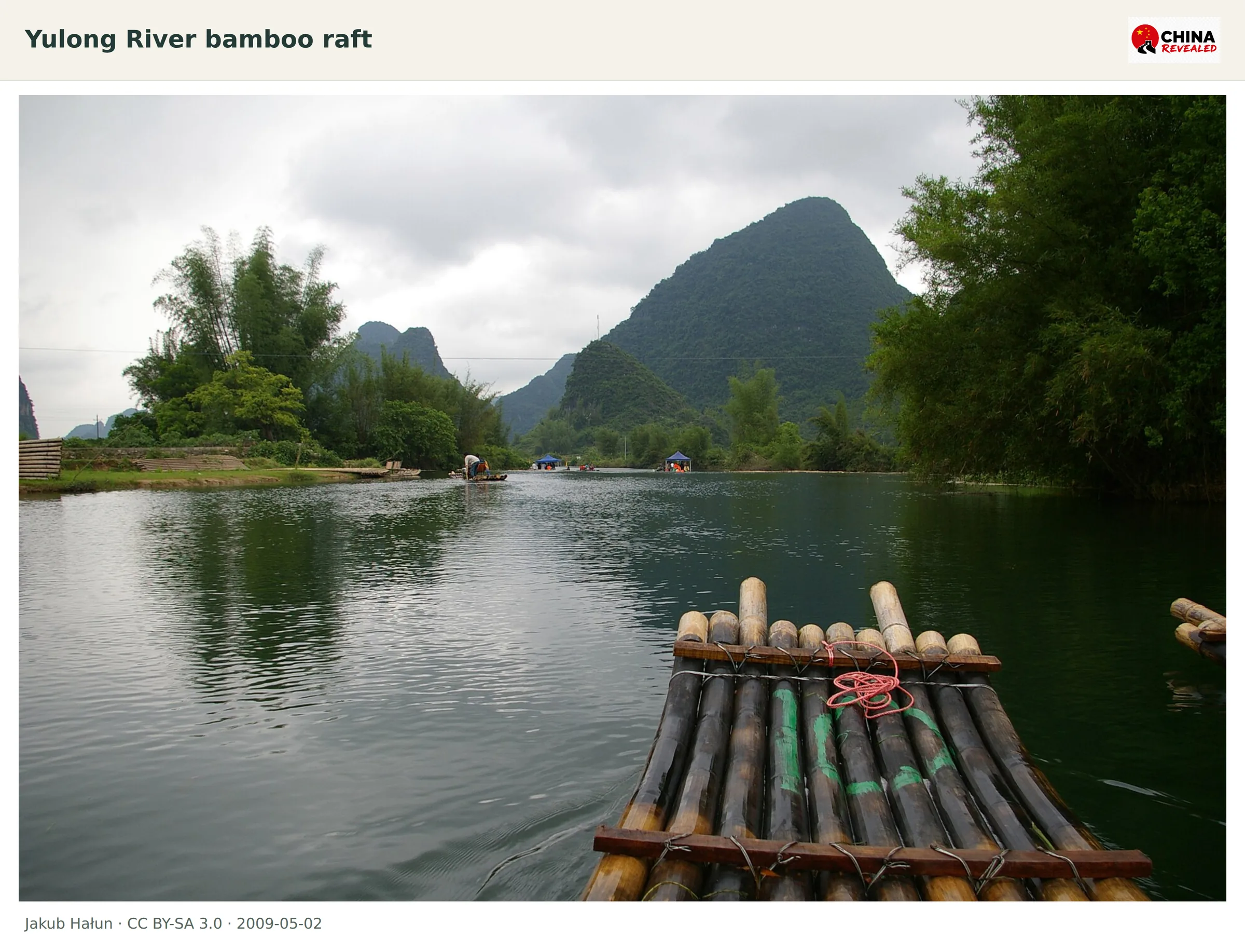 A bamboo raft floats on the Yulong River beneath Yangshuo karst hills